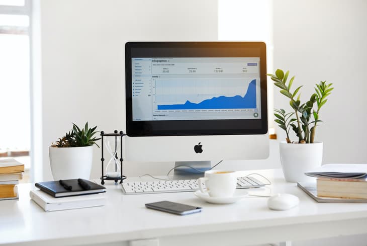 Displaying the Google Analytics stats on a desktop screen at a white desk